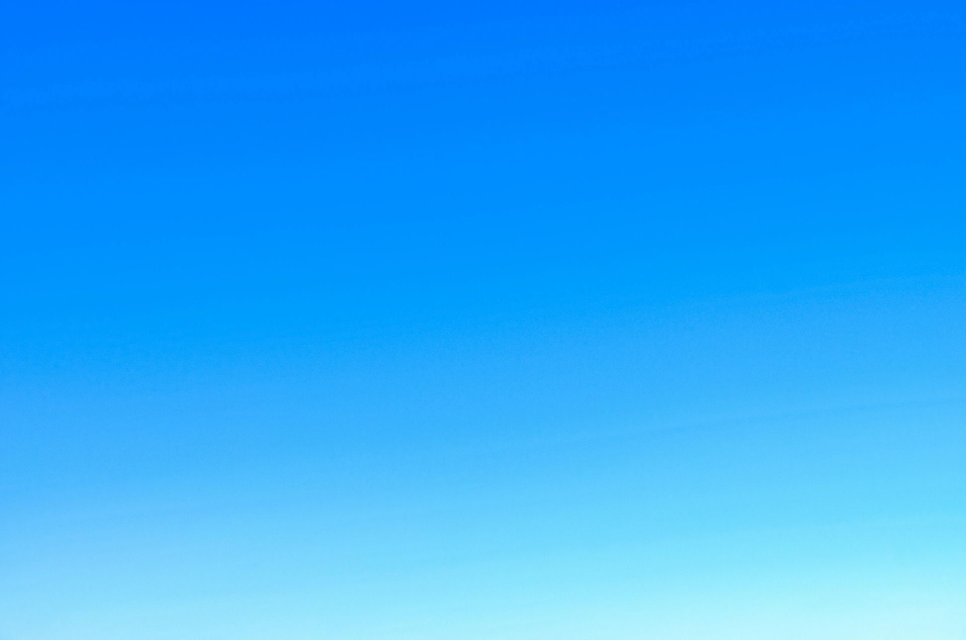 A serene view of a vibrant clear blue sky with a subtle gradient, perfect for backgrounds.