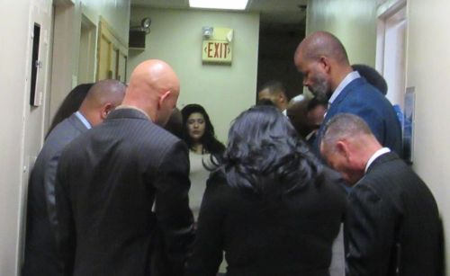 A young child in Tanzania prays in contemplation during a community gathering, symbolizing faith and innocence.